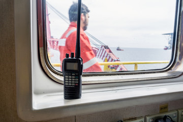 Walkie talkie on a window of a construction barge at oil field
