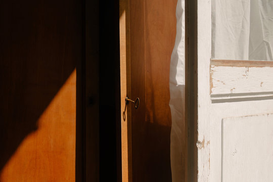 Sunlight shining through an open door with key in lock