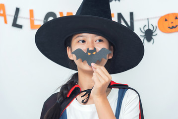 Asian girl witch costume playing in the room Happy Halloween Day 2019.