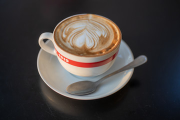 A cup of cappuccino with a spoon