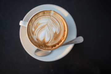 A cup of cappuccino with a spoon