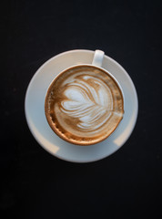 A cup of cappuccino on black