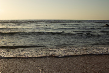 Summer background of hot sand with sea or ocean wave bubbles with copy space for card or advertisement at dawn or sunset