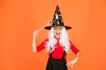Magical spell. Little child in witch costume. Halloween party. Small girl in black witch hat. Autumn holiday. Join celebration. Magical spell. Small witch with white hair. Wizard with magic stick