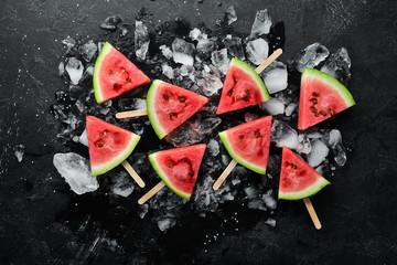 summer watermelon slice popsicles on ice. Top view. Free copy space.