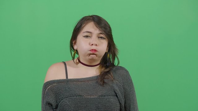 Woman Inflating The Cheeks. Studio Isolated Shot Against Green Screen Background