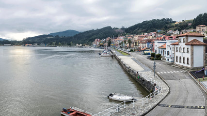 Naklejka premium vistas de un muelle con barcos fondeados y grúas