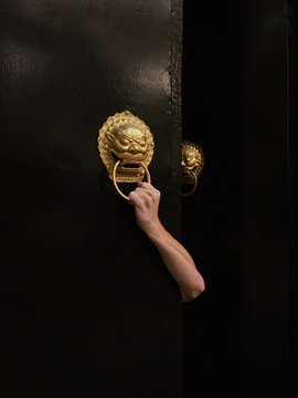 Man's hand holding door knocker