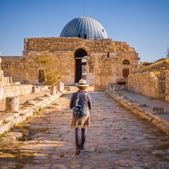 Lady walking along Colonnated Street toward the Monumental Gateway at Umayyad Palace, Amman Citadel, Amman, Jordan - obrazy, fototapety, plakaty