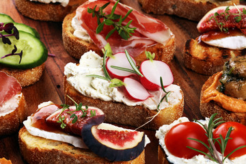 Assorted bruschetta with various toppings. Appetizing bruschetta or brie crostini. Variety of small sandwiches. Mix bruschetta on table