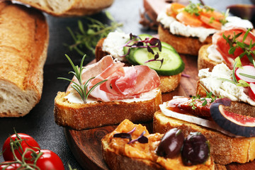 Assorted bruschetta with various toppings. Appetizing bruschetta or brie crostini. Variety of small sandwiches. Mix bruschetta on table