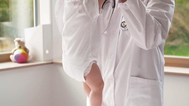 medicine, healthcare and pediatrics concept - female pediatrician or neuropathist doctor or nurse taking baby girl at clinic or hospital