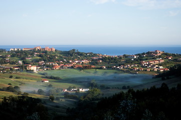 Fototapeta na wymiar A view of Comillas behind the fog of the morning. Cantabria, Spain