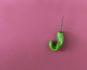 Trendy ugly organic hot pepper on pink background.