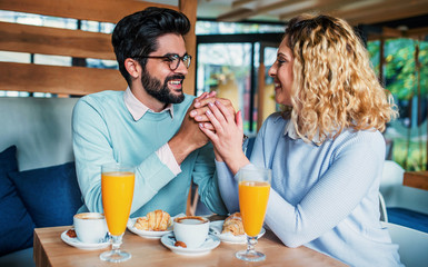 Couple sitting in a cafe, having breakfast. Love, dating, food, lifestyle concept