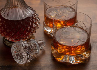 A bottle with two glasses of whisky