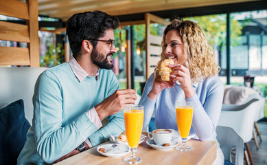 Couple sitting in a cafe, having breakfast. Love, dating, food, lifestyle concept