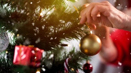 holidays and people concept - senior woman decorating christmas tree at home
