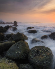 Fototapeta na wymiar sunset background on a beach with breakwater objects, dreamland nuance