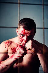 Strong aggressive monster behind grid. Bodybuilder nude torso soiled blood. Prison for monster....