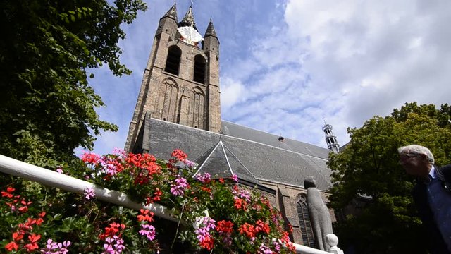 Delft, Holland, August 2019. The bell tower of the old church, the Oude Kerk, stands out imposingly over the city. Planters give color to the image.