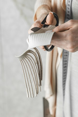 Woman cutting leather fringe for handbag details