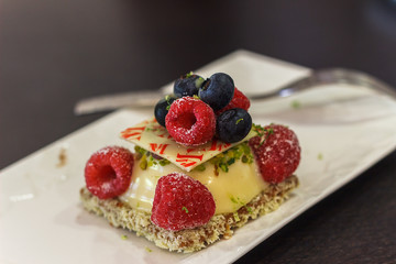 Delicatessen cake. Delicate crispy cake with cream, white chocolate and red fruits. Food concept