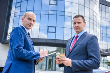 Two men in suit making deal outdoors