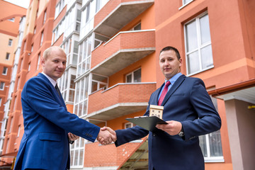 Agent with buyer posing on construction site