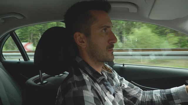 Angry man driver shows middle finger, road rage, profile interior shot