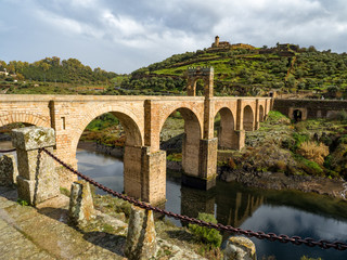 The Puente de Alcantara, a Roman arch bridge in Toledo, Catile-La Mancha, Spain, spanning the Tagus River. The word comes from Arabic bridge