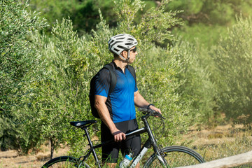 Obraz premium Male cyclist standing with his bike