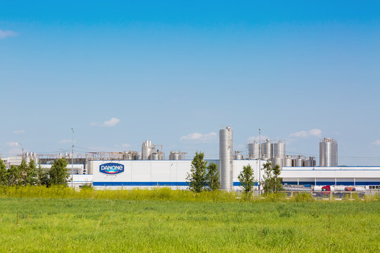 MOSCOW REGION, RUSSIA - AUGUST, 2017: Danone factory in Russia with green grass and blue sky