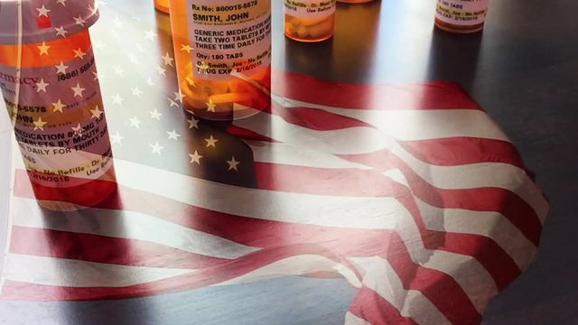 4k Slow Motion Medicine Bottles and Pills Falling With Ghosted American Flag Waving. The medicine bottle labels are non-proprietary with fictitious names, addresses and information designed specifical