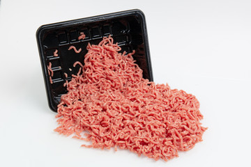 Raw minced meat in a black plastic container on white background