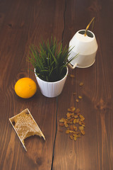 honey in combs next to raisins with green grass leaves on a wooden background