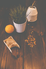honey in combs next to raisins with green grass leaves on a wooden background