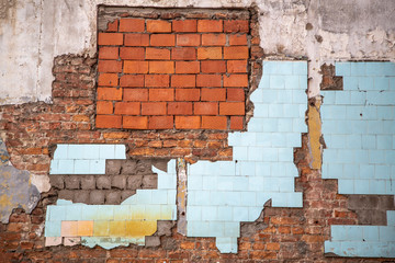 old ruined red brick wall of a house with blue tile and white concrete. rough surface texture