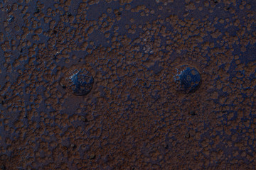 fragment of a rusty metal floor with large rivets