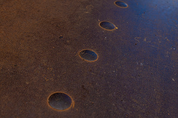 fragment of a rusty metal floor with large rivets