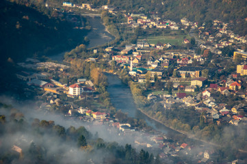 Houses and trees in the morning fog in autumn