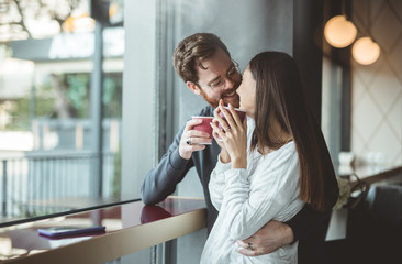 Happy couple enjoying hot drink in cafe
