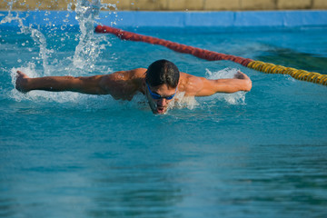 Swimmer standing next to a pool on a sunny morning