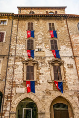 View on a medieval palace of Narni, with medieval flags, Umbria - Italy