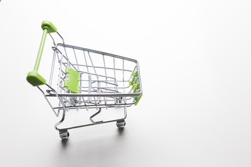 Grocery cart with light green handles on a white isolated background close-up.