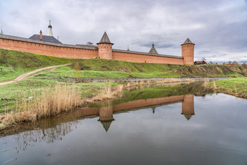 Naklejka premium Walls and towers of Spaso-Evfimiev (Saint Euthymius) Monastery with reflection in Kamenka river in Suzdal, a well preserved old Russian town-museum. A member of the Golden ring of Russia