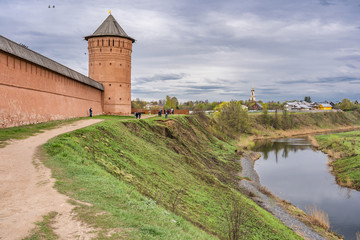 Fototapeta na wymiar Walls and towers of Spaso-Evfimiev (Saint Euthymius) Monastery with reflection in Kamenka river in Suzdal, a well preserved old Russian town-museum. A member of the Golden ring of Russia