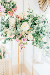 Floral wedding decoration. Wedding table setting decorated with fresh flowers. Wedding floristry. Bouquet with roses, eustoma and eucalyptus leaves.