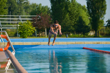 Naklejka premium Swimmer standing next to a pool on a sunny morning