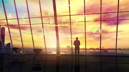 In the office, lit by the setting sun, stands a silhouette of a man.
